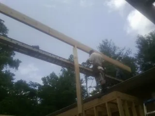 Carpenter setting a ridge beam over a new addition frame — Ice Dam Removal by Roofing Brothers in Yemassee