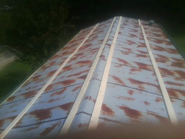 Rusted metal roof panels with new wood purlins before replacement — Storm Damage Roof Repair in Yemassee by Roofing Brothers