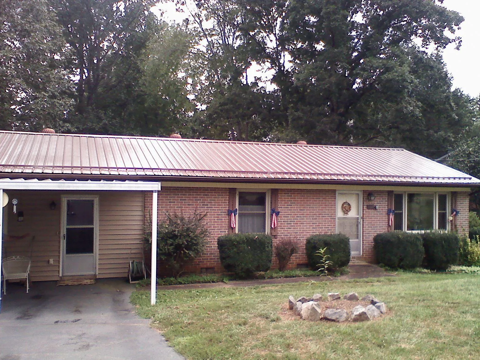 Bronze metal roof and carport on a brick ranch home — Roof Repair work by our crew in Yemassee